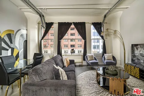 a living room with furniture a fireplace and a floor to ceiling window