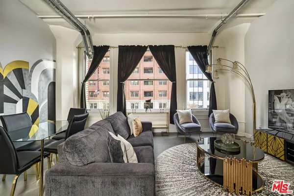 a living room with furniture a fireplace and a floor to ceiling window