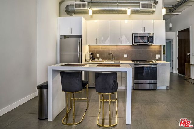 a kitchen with stainless steel appliances granite countertop a stove a refrigerator and a sink