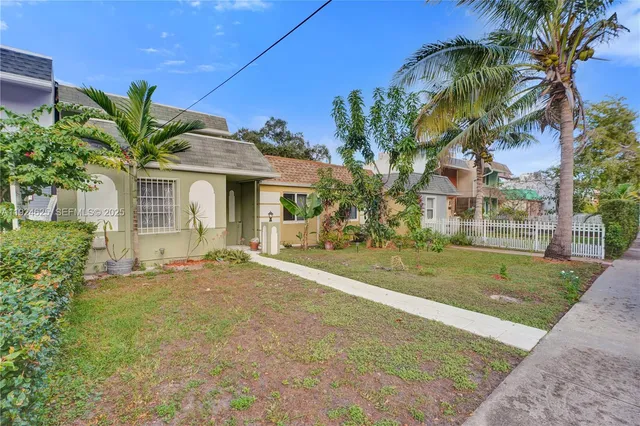 a view of a house with a yard and potted plants