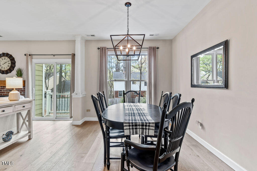 112 Oxpens Road Cary, NC 27513 - Photo 13 of 37 a dining room with furniture a chandelier and wooden floor