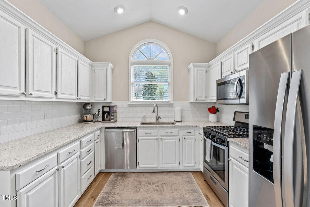 112 Oxpens Road Cary, NC 27513 - Photo 17 of 37 a kitchen with cabinets stainless steel appliances a sink and a window