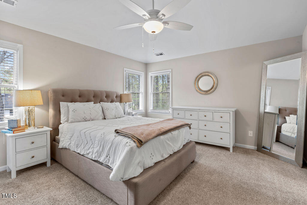 112 Oxpens Road Cary, NC 27513 - Photo 23 of 37 a spacious bedroom with a bed and a chandelier