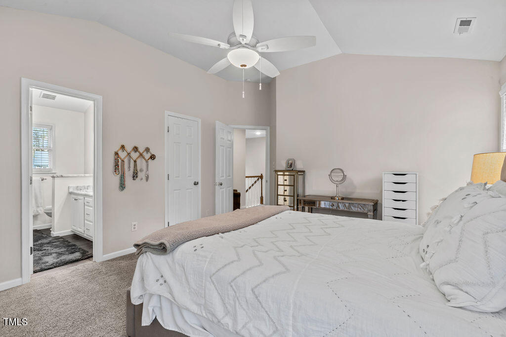 112 Oxpens Road Cary, NC 27513 - Photo 24 of 37 a spacious bedroom with a bed and a chandelier