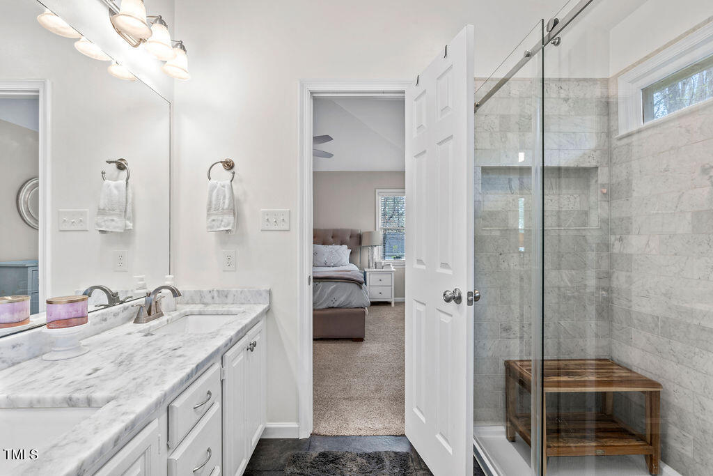 112 Oxpens Road Cary, NC 27513 - Photo 26 of 37 a spacious bathroom with a granite countertop sink a mirror and shower