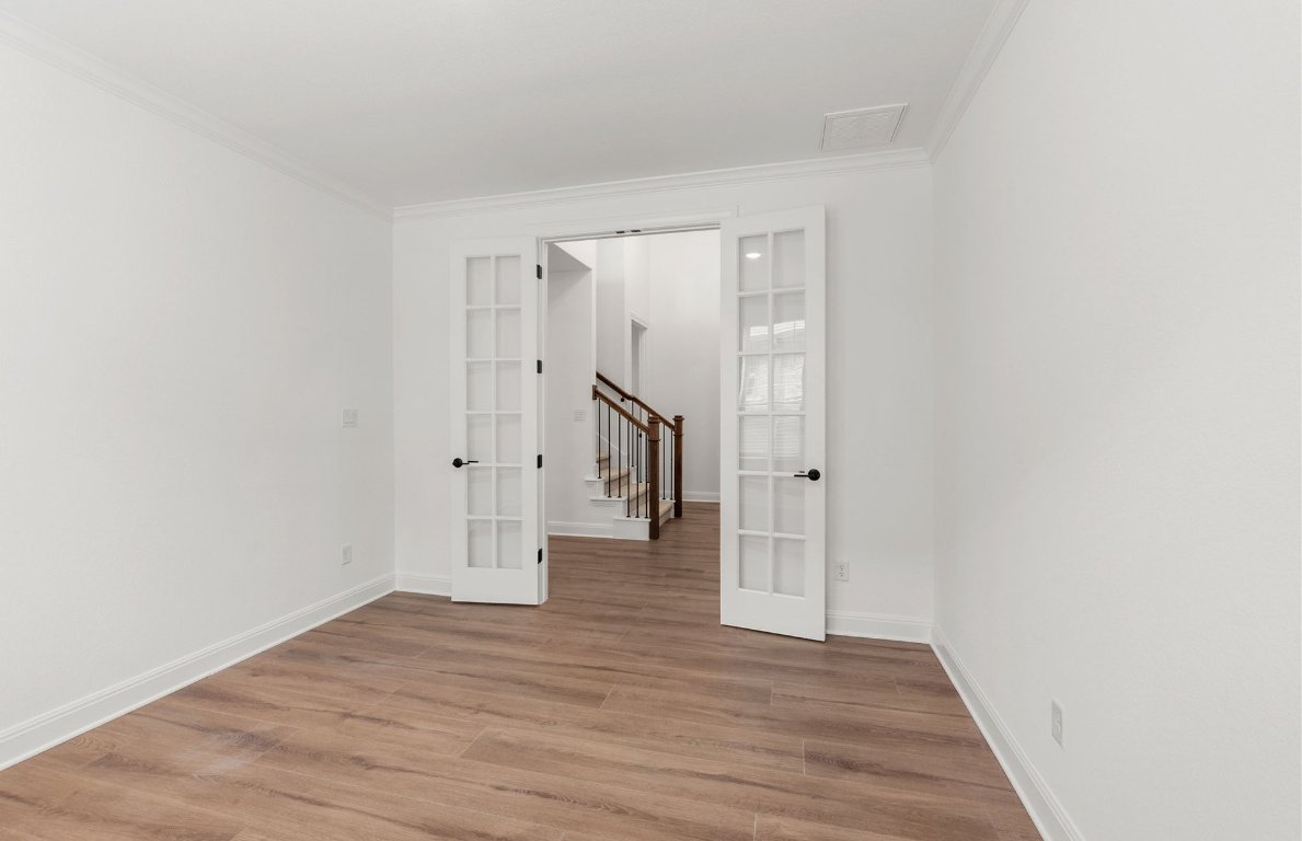 829 Round Mountain Pass Georgetown, TX 78628 - Photo 8 of 17 a view of an empty room with wooden floor and stairs