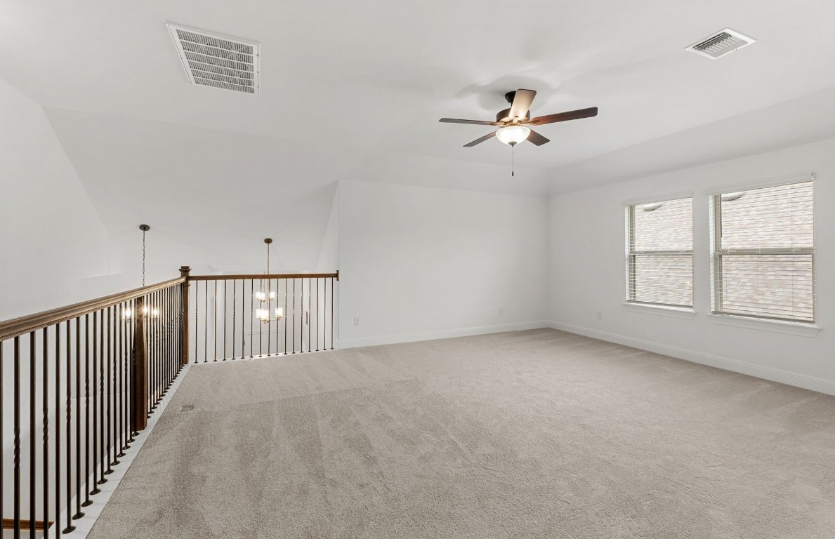 829 Round Mountain Pass Georgetown, TX 78628 - Photo 9 of 17 an empty room with chandelier fan and windows