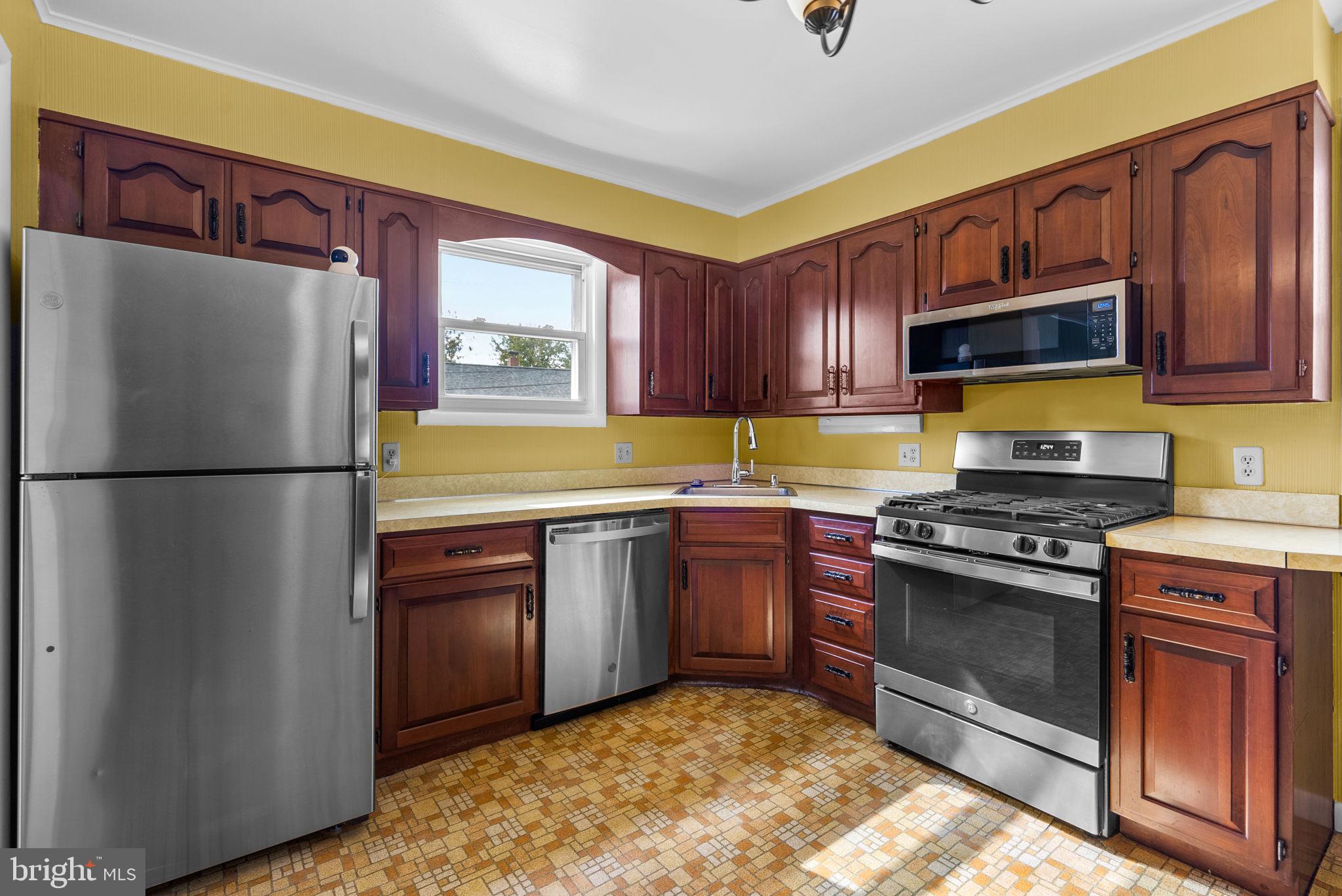 8700 50th Place College Park, MD 20740 - Photo 10 of 33 a kitchen with stainless steel appliances granite countertop a refrigerator stove top oven and sink