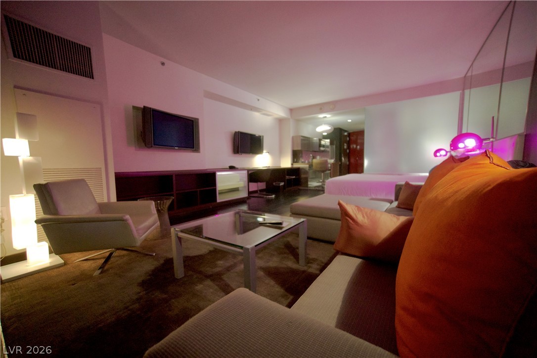 4381 West Flamingo Road, Unit 3616 Las Vegas, NV 89103 - Photo 20 of 29 A well-lit room, features rich dark flooring and a comfortable seating area, perfect for relaxing.