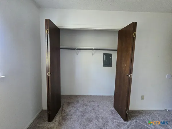 a kitchen with stainless steel appliances a refrigerator a sink a stove a microwave a counter top and white cabinets