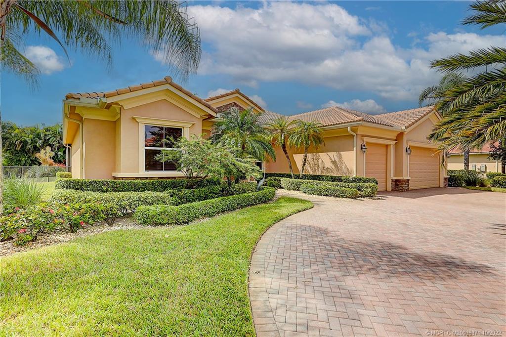 7426 Southeast Laque Circle Stuart, FL 34997 - Photo 20 of 81 a front view of a house with a yard and garage