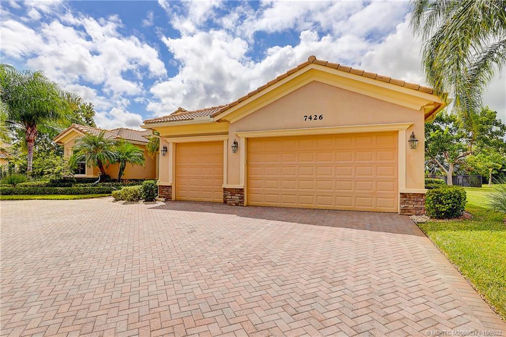 7426 Southeast Laque Circle Stuart, FL 34997 - Photo 21 of 81 a front view of a house with a yard and garage