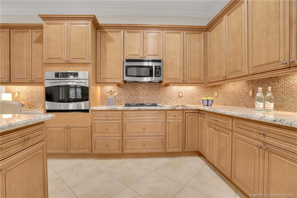 7426 Southeast Laque Circle Stuart, FL 34997 - Photo 34 of 81 a kitchen with stainless steel appliances granite countertop a refrigerator and cabinets