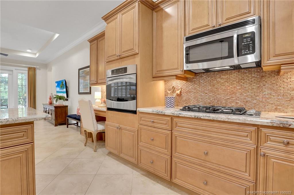 7426 Southeast Laque Circle Stuart, FL 34997 - Photo 39 of 81 a kitchen with stainless steel appliances granite countertop a stove microwave and cabinets