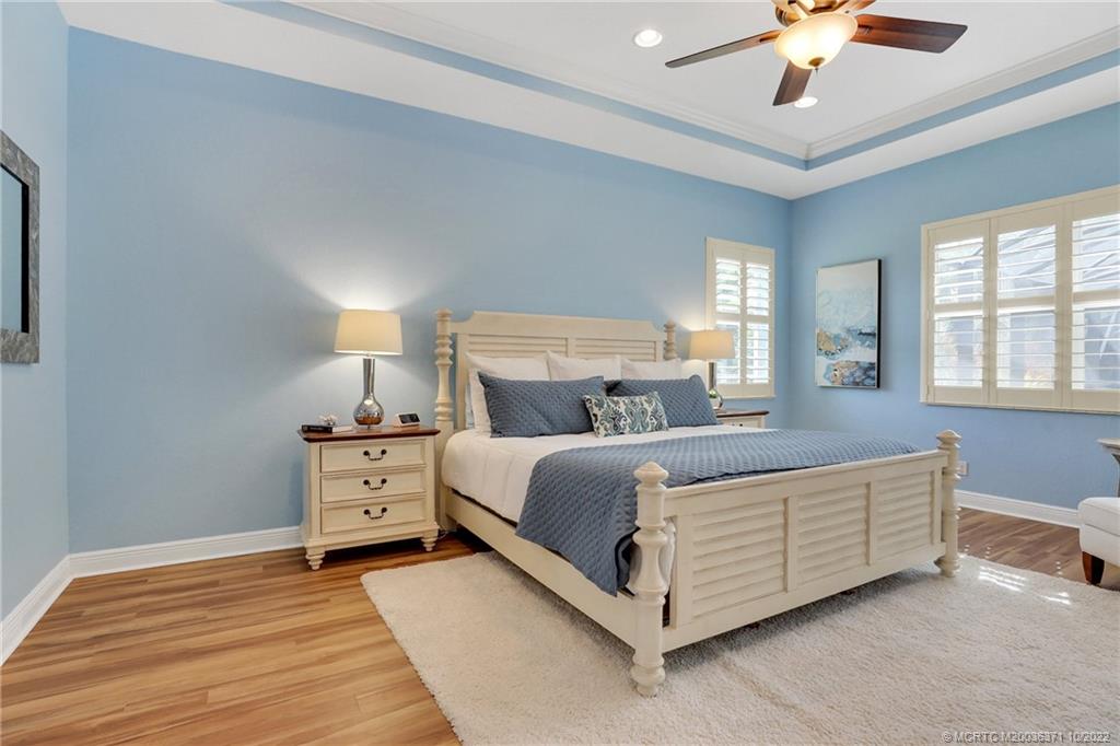 7426 Southeast Laque Circle Stuart, FL 34997 - Photo 52 of 81 a bed room with a bed and a chandelier