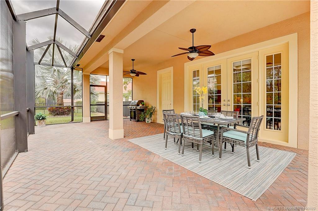 7426 Southeast Laque Circle Stuart, FL 34997 - Photo 9 of 81 a dining room with wooden floor a chandelier a wooden table and chairs