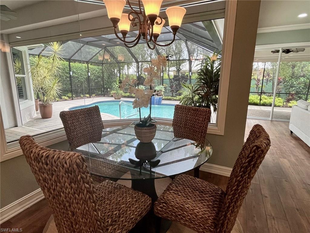 4956 Rustic Oaks Circle Naples, FL 34105 - Photo 13 of 37 a view of an outdoor dining space with furniture and wooden floor