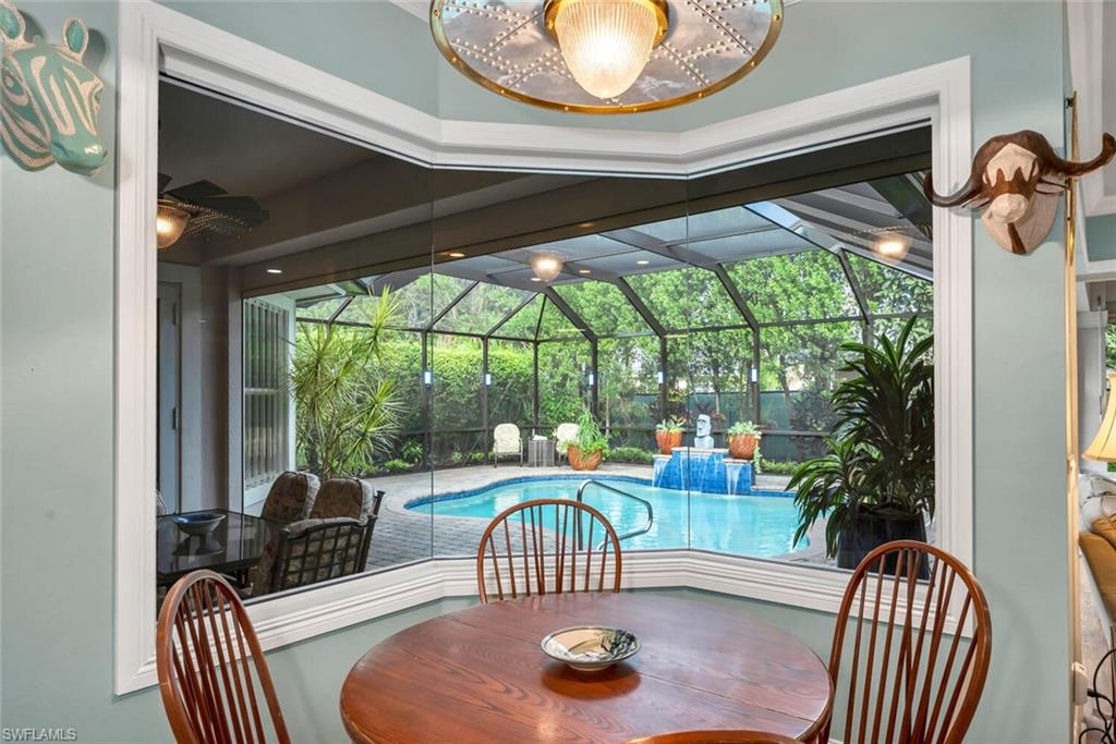4956 Rustic Oaks Circle Naples, FL 34105 - Photo 21 of 37 a living room with furniture and a floor to ceiling window
