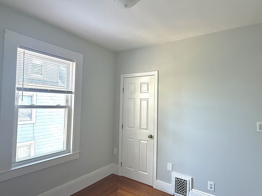 19-21 Dearborn Avenue, Unit 2 Lynn, MA 01905 - Photo 12 of 20 a view of an empty room with wooden floor and a window