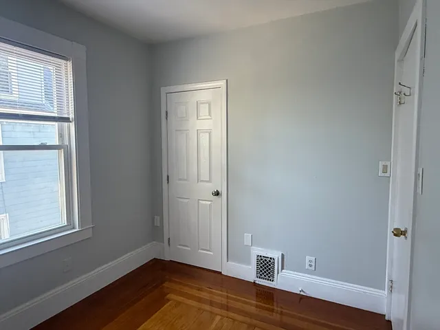 a view of room with window and wooden floor