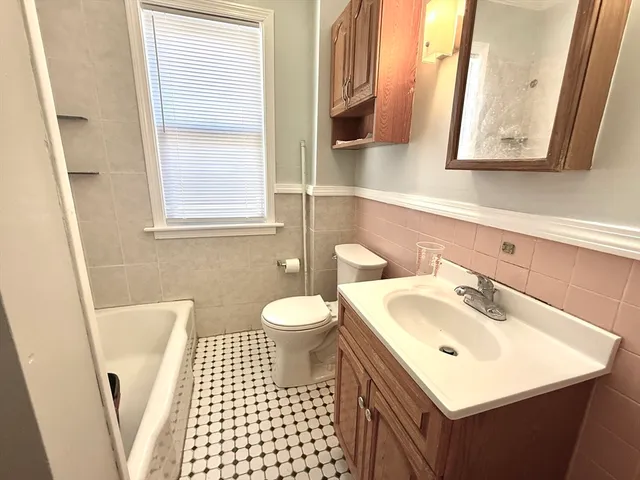 a bathroom with a sink a toilet and a window