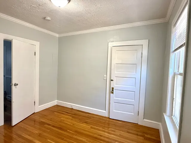 a view of empty room with wooden floor