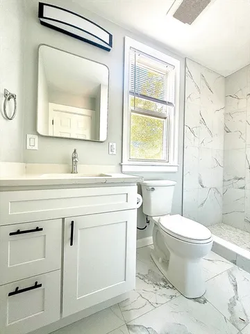 a bathroom with a toilet sink and mirror