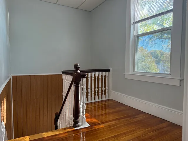a view of staircase with wooden floor and a window