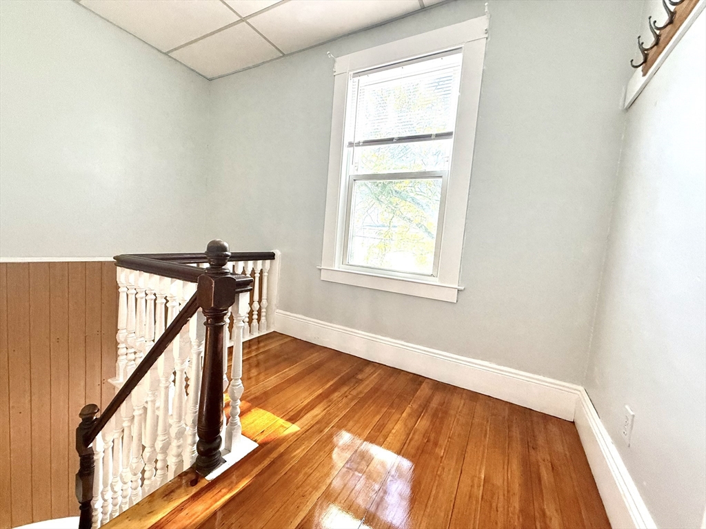 19-21 Dearborn Avenue, Unit 2 Lynn, MA 01905 - Photo 6 of 20 a view of an empty room with wooden floor and a window