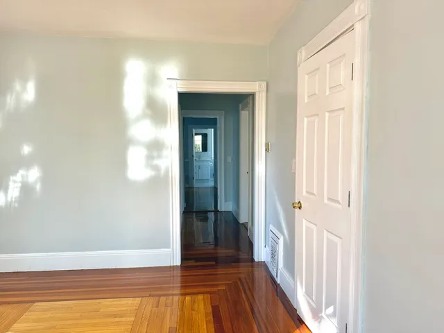 a view of a livingroom with wooden floor and a bathroom