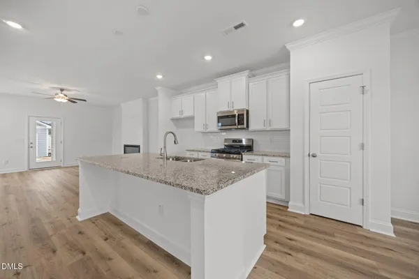 a view of an empty room with a kitchen
