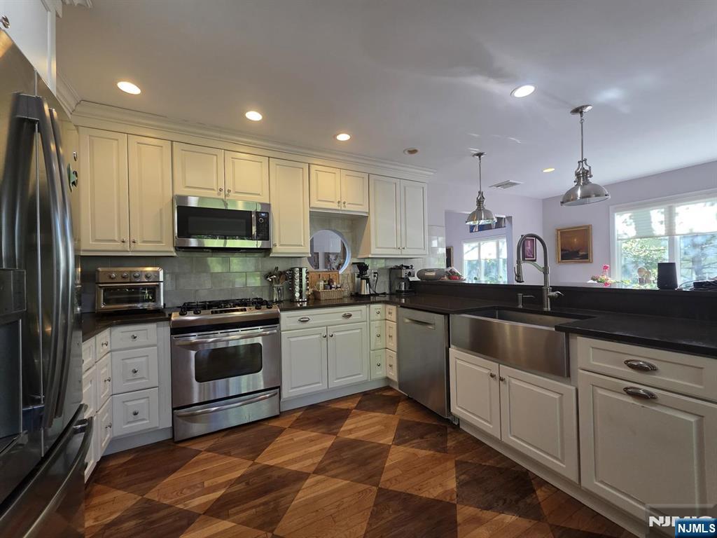 33 Cedar Lane Closter, NJ 07624 - Photo 11 of 44 a kitchen with stainless steel appliances granite countertop a sink a stove a refrigerator and cabinets