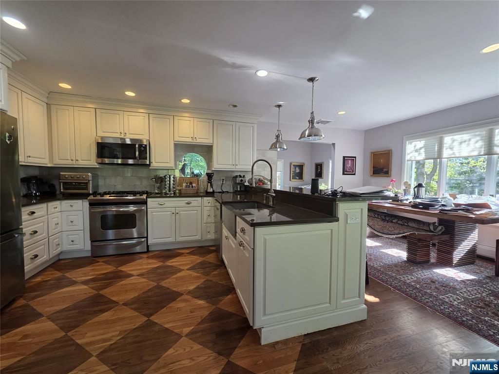 33 Cedar Lane Closter, NJ 07624 - Photo 13 of 44 a kitchen with stainless steel appliances kitchen island granite countertop a stove a sink and a refrigerator
