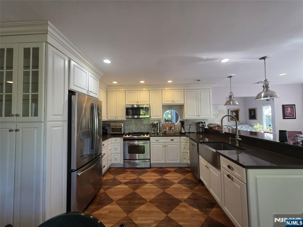 33 Cedar Lane Closter, NJ 07624 - Photo 14 of 44 a large kitchen with stainless steel appliances granite countertop a sink and a stove
