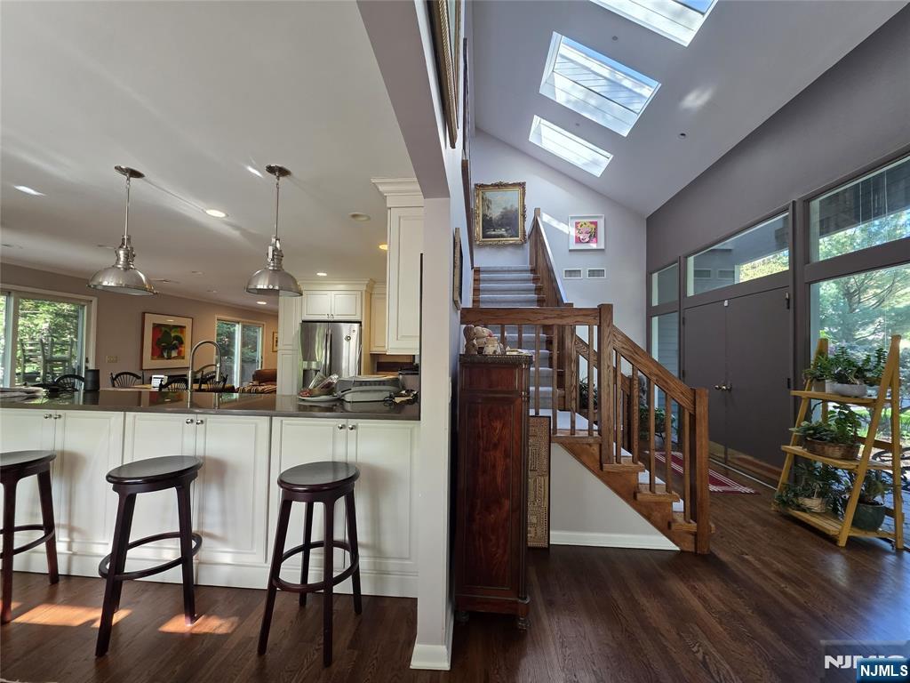 33 Cedar Lane Closter, NJ 07624 - Photo 17 of 44 a kitchen with stainless steel appliances granite countertop table chairs and a wooden floor