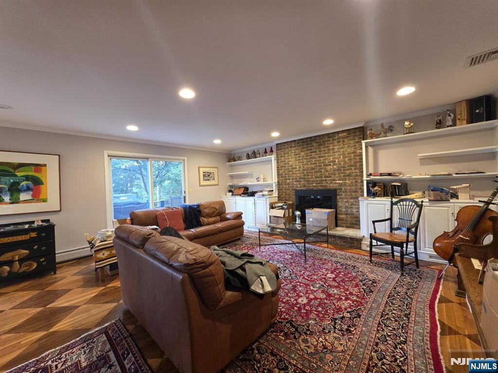 33 Cedar Lane Closter, NJ 07624 - Photo 26 of 44 a living room with furniture a fireplace and a flat screen tv
