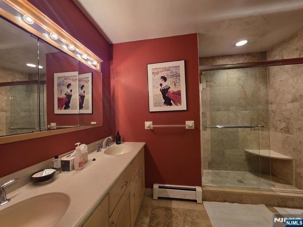 33 Cedar Lane Closter, NJ 07624 - Photo 35 of 44 a bathroom with a tub sink and mirror