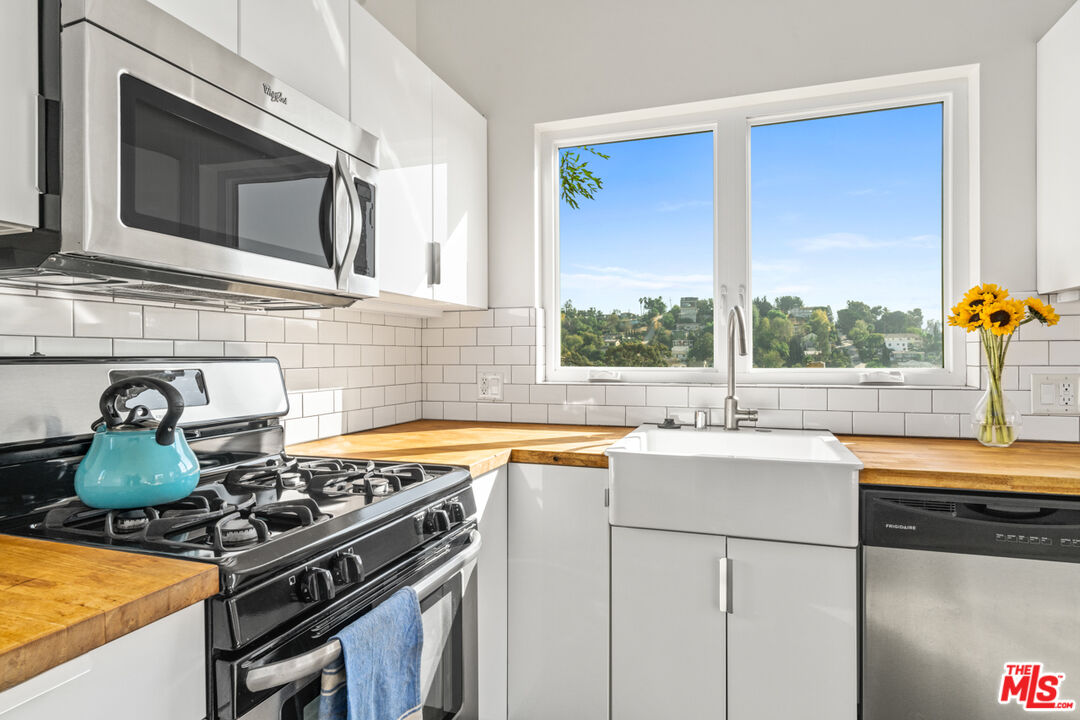 2275 Ewing Street Los Angeles, CA 90039 - Photo 8 of 19 a kitchen with stainless steel appliances granite countertop a sink stove and microwave
