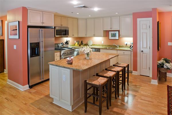 a kitchen with refrigerator a sink and chairs