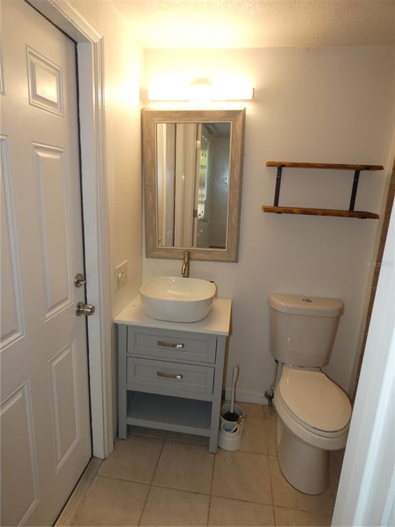 4832 Elmwood Street New Port Richey, FL 34653 - Photo 16 of 24 a bathroom with a toilet a sink and mirror