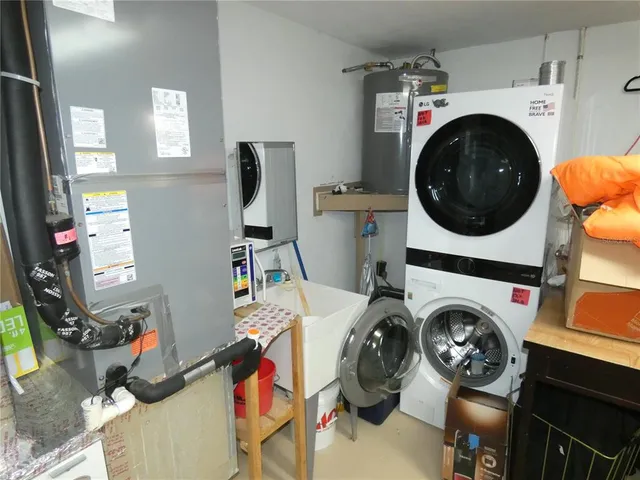 a utility room with dryer washer and a view of living room