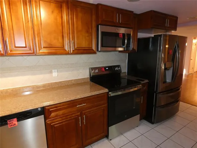 a kitchen with granite countertop cabinets stainless steel appliances and a window