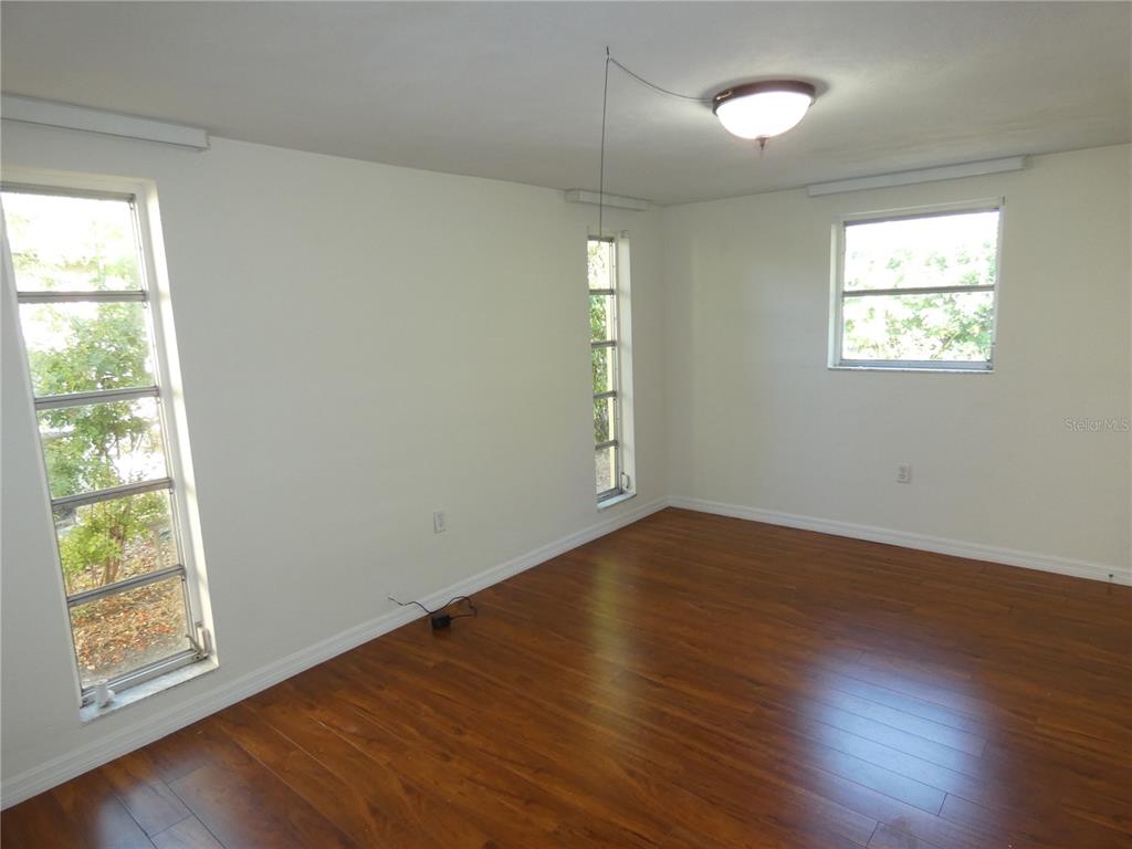 4832 Elmwood Street New Port Richey, FL 34653 - Photo 8 of 24 an empty room with wooden floor and windows