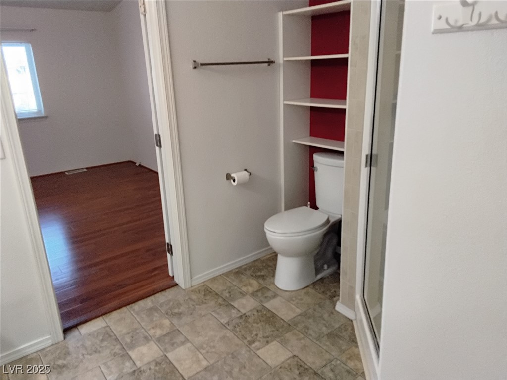 2911 Rio Rico Drive, Unit 4 Pahrump, NV 89048 - Photo 19 of 22 bathroom featuring a stall shower, baseboards, and toilet