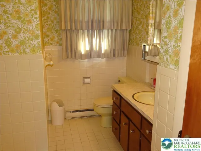 a bathroom with a sink a toilet and shower curtain