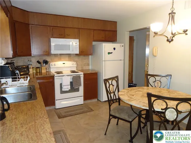 a kitchen with a stove a refrigerator and a table