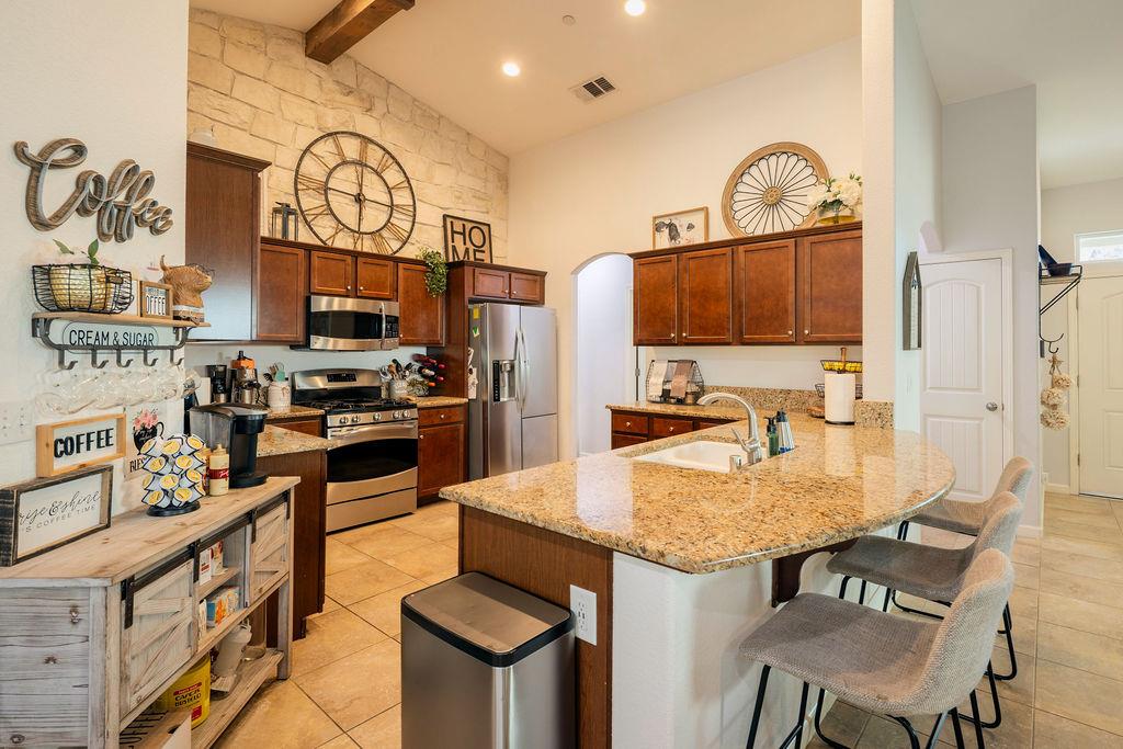602 South Filbert Avenue Fresno, CA 93727 - Photo 12 of 50 a kitchen with stainless steel appliances granite countertop a stove top oven a sink a dining table and chairs with wooden floor