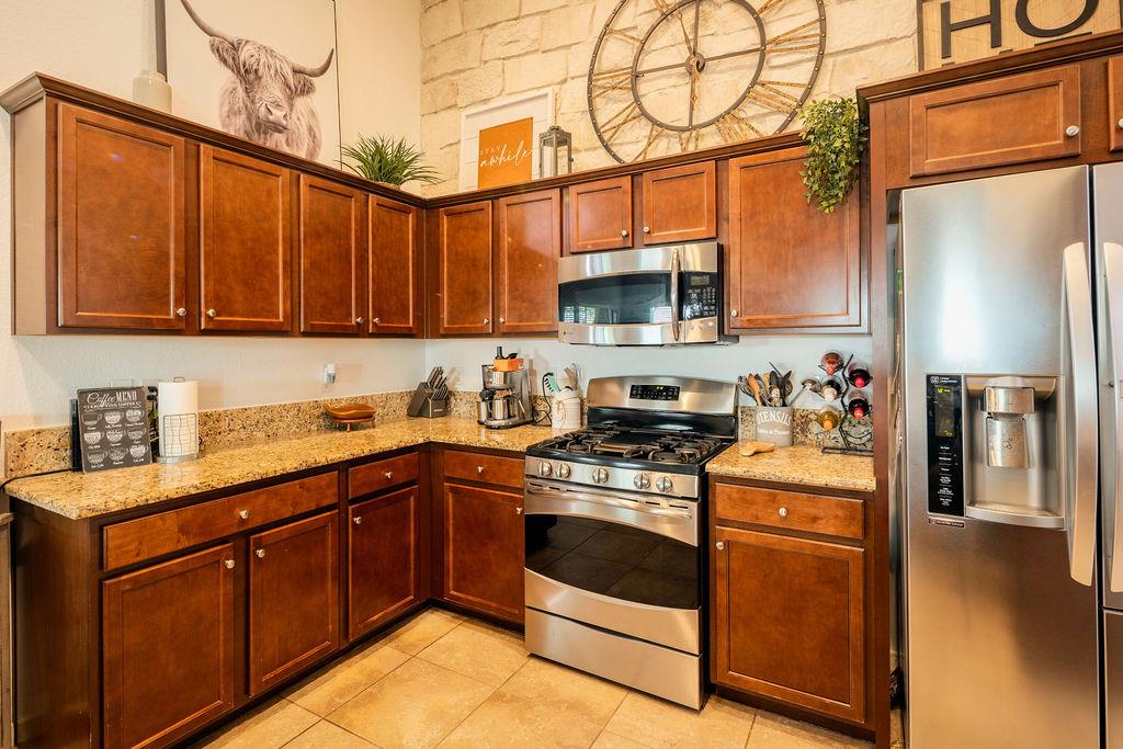 602 South Filbert Avenue Fresno, CA 93727 - Photo 14 of 50 a kitchen with stainless steel appliances granite countertop a stove a sink dishwasher and a refrigerator with wooden cabinets