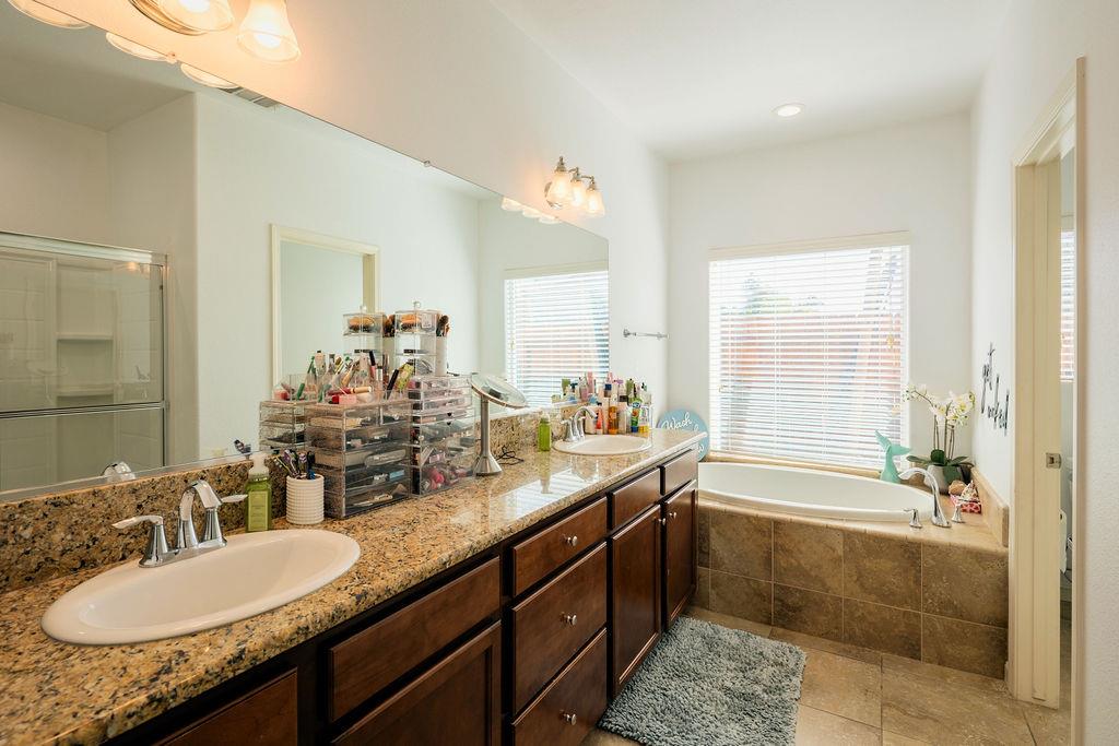 602 South Filbert Avenue Fresno, CA 93727 - Photo 33 of 50 a bathroom with double vanity sinks double vanity tub shower and a mirror