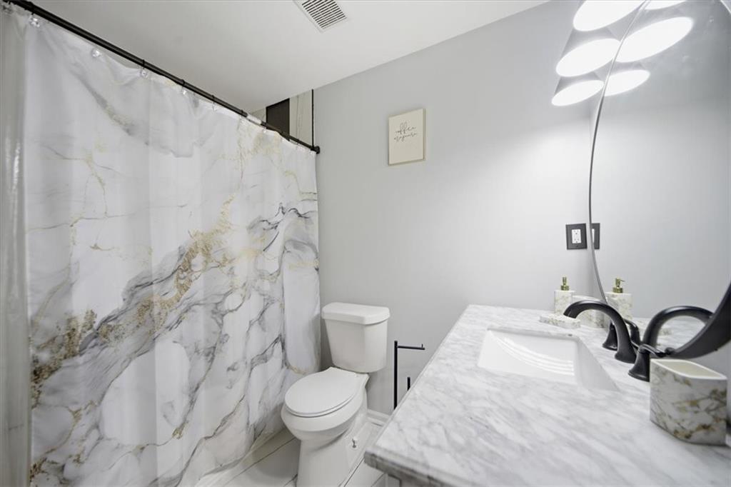 1039 Mariners Court Stone Mountain, GA 30083 - Photo 35 of 60 a bathroom with a granite countertop sink a toilet and a shower